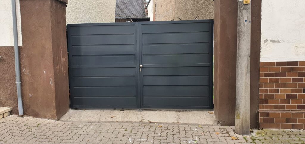 Aluminium-Hoftor mit waagerechter Lattung in einem gemauerten Torbogen