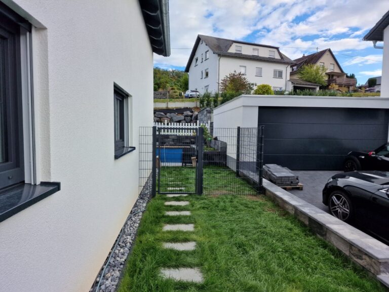Doppelstabzaun neben dem Gartenweg eines Neubaus