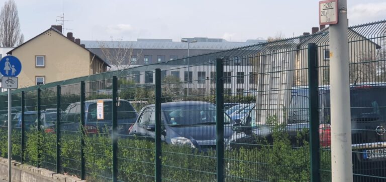 Zaunanlage mit abgeschrägter Oberkante entlang eines Parkplatzes