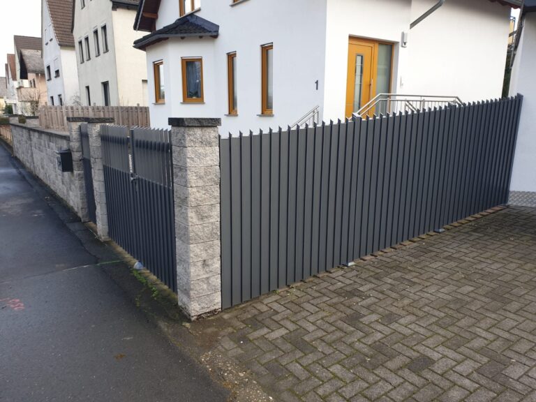 Lattenzaun als blickdichte Abgrenzung einer Hofeinfahrt
