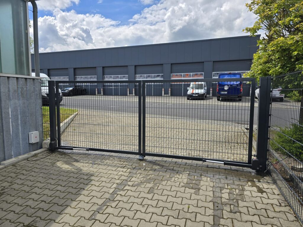 Freitragendes Schiebetor in Anthrazit vor einer Gewerbehalle