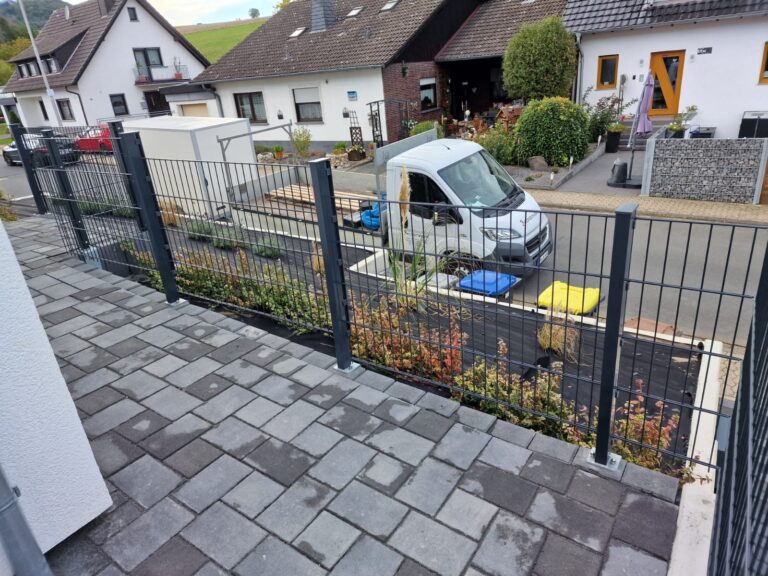 Anthrazitfarbener Schmuckzaun mit Rundstäben vor einem Neubau