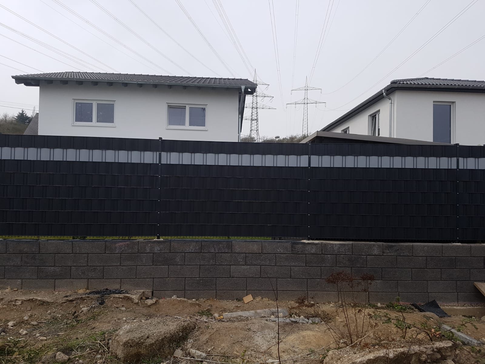 Sichtschutzzaun auf einer Betonsteinmauer bei kühlem Wetter