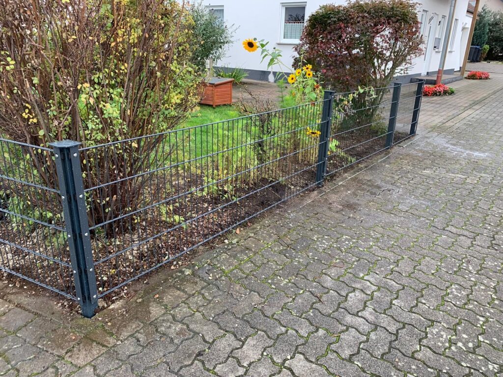 Niedriger Doppelstabzaun am Vorgarten eines Wohnhauses