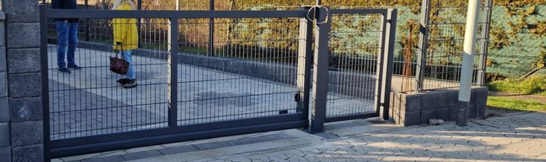 Detailansicht des Einfahrtstors mit angrenzendem Doppelstabzaun